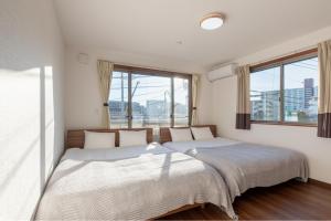 东京Residencial Voyan 南砂町的带2扇窗户的客房内的2张床