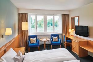 莱茵费尔登斯池艾瑞酒店的酒店客房设有一张床、一张书桌和一台电视机。