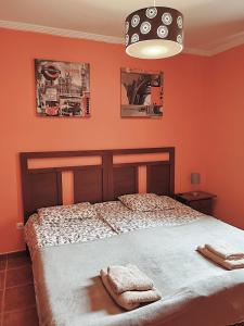 厄尔梅达诺Bungalow with 2 bedrooms, Playa la Tejita的一间卧室拥有橙色的墙壁,床上配有2条毛巾