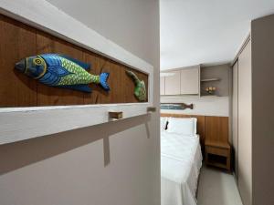 维拉维尔哈Mar & Descanso Itaparica的卧室在床边墙上挂着鱼