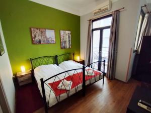 塞萨洛尼基塞萨洛尼基出租旅馆的一间卧室配有一张带绿色墙壁的床