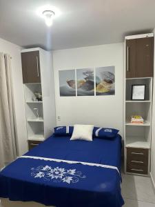 BayeuxAero-Quarto Aconchegante的一间卧室配有蓝色的床和一些书架