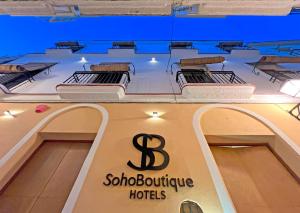 加的斯Soho Boutique Cádiz的带有三张床的精品酒店的标志