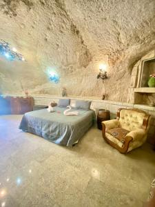 拉卡布雷拉Cueva romántica - Jacuzzi的洞穴内一间卧室,配有一张床和一把椅子
