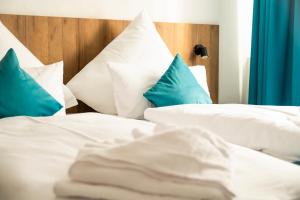 斯图加特Hotel Hansa Stuttgart City的一间卧室配有两张带蓝白色枕头的床