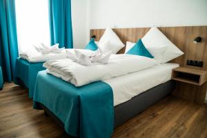 斯图加特Hotel Hansa Stuttgart City的两张位于酒店客房的床,配有蓝色窗帘