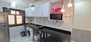 巴加Tony's Inn Baga Apartment的厨房配有水槽、洗衣机和烘干机
