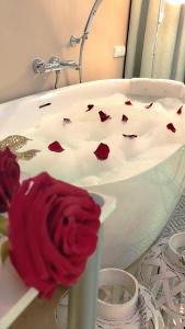 弗瓦迪斯瓦沃沃Elegante-Kameralny Aparthotel的浴缸边的红玫瑰