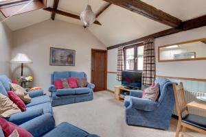 科尔切斯特Birds Farm的客厅配有2把蓝色椅子和电视