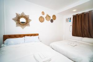 圣巴勃罗Villa Soledad Garden Resort的一间卧室设有两张床,墙上设有一面镜子