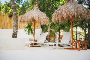 圣巴勃罗Villa Soledad Garden Resort的海滩上的一组椅子和遮阳伞