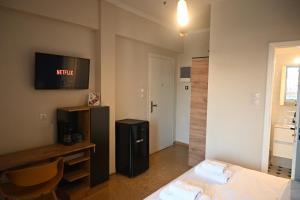 雅典SuperHost Hub #510 Plaka - Monastiraki的酒店客房设有一张床和墙上的电视