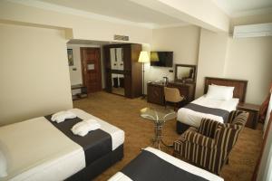迪亚巴克尔Malabadi Hotel的酒店客房,配有两张床和椅子