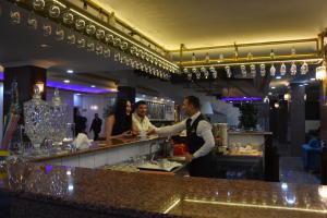 迪亚巴克尔Malabadi Hotel的站在酒吧的男人和女人