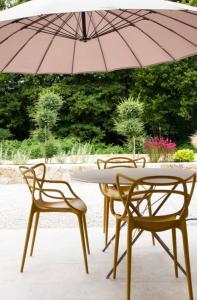 Casa Ghjuvan Matteu的两张椅子和一张带雨伞的桌子