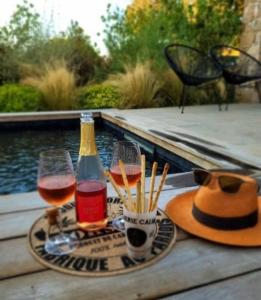 Casa Ghjuvan Matteu的一张桌子,上面放着两杯葡萄酒和一顶帽子