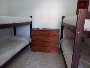 圣贝尔纳多Hotel.Aires de Libertad的一间卧室设有两张双层床和木制梳妆台。