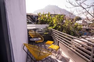 圣地亚哥The Hip Hotel Santiago的阳台配有黄色椅子和桌椅。