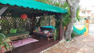 弗洛里亚诺波利斯Pousada Girassois Hostel的一个带绿色沙发和树的庭院