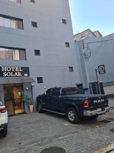 圣保罗Hotel Solar Bela Vista的停在大楼前的一辆蓝色卡车