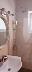 盖奥斯Paxos Rock Apartments的带淋浴和白色盥洗盆的浴室