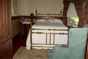 波特兰弗利特伍德住宿加早餐旅馆的一间卧室配有一张床和一把椅子