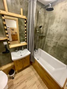 斯基希德尼萨Nafta Aparts & Villas的一间带水槽、浴缸和卫生间的浴室
