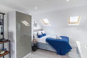 伦敦Modern Studio Rooms in Zone 2 London的一间卧室配有一张带蓝色床单和天窗的床。