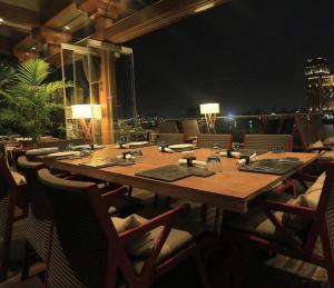 开罗Riverside Hotel的阳台配有一张大木桌和椅子