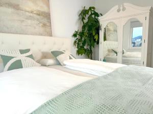 格蒙登Traunseeresidenzen的一间卧室配有两张白色的床和镜子