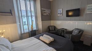 滕比克罗尔兰德宾馆的一间卧室配有一张床、一把椅子和电视