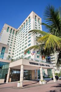 里约热内卢温莎芭拉酒店的一座大建筑,前面有棕榈树