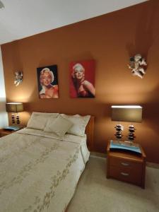 瓦莱塔Tal-Munfuha- Centrally Located Space.的卧室配有一张床,墙上挂有两张照片