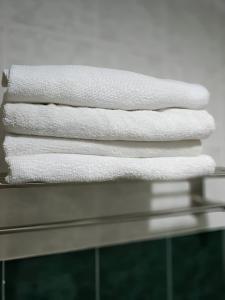 波德申3 BEDROOM SEAVIEW CONDO @ GLORY BEACH RESORT, PORT DICKSON的一堆置在架子上的白色毛巾