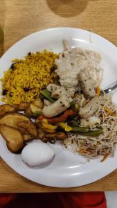 古瓦哈提N.K. Residency的米饭和肉的白盘食物