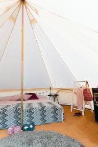 埃克舍Glamping in Småland的一间卧室配有一张床和一个帐篷