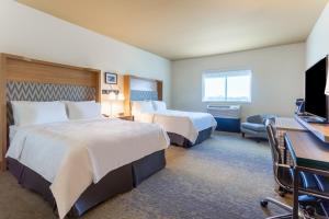 锡达福尔斯Holiday Inn & Suites Cedar Falls-Waterloo Event Ctr, an IHG Hotel的酒店客房配有两张床和一张书桌