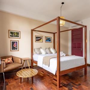 马瑙斯Hotel Casa do Bispo的一间卧室配有天蓬床和沙发