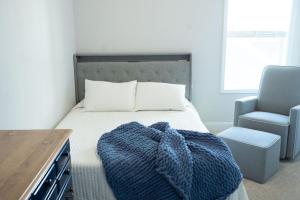 CarthageSleeps 9- In Whispering Pines的一间卧室配有一张带蓝色毯子和椅子的床