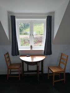 谢普顿马利特Farm Loft的窗前的一张桌子和两把椅子