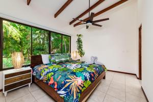 普拉亚弗拉明戈Pacific Garden Villas # 6 REEL PARADISE的一间卧室设有一张床和一个大窗户