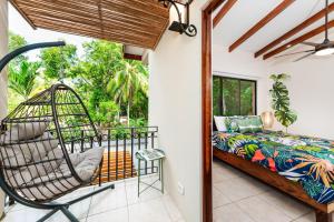普拉亚弗拉明戈Pacific Garden Villas # 6 REEL PARADISE的一间带床和秋千的阳台