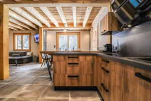 莫尔济讷Alpen Chalet的一个带木制橱柜和桌子的大厨房