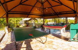 金巴亚Hotel Campestre Nogal de Cafetal的一个带乒乓球桌和大雨伞的庭院