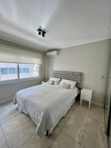 布宜诺斯艾利斯Apart de categoría con amenities y estacionamiento的白色的卧室设有一张大床和一个窗户