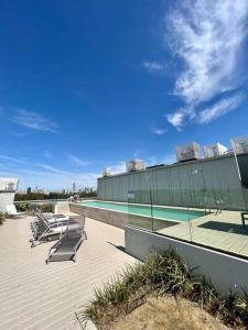 布宜诺斯艾利斯Apart de categoría con amenities y estacionamiento的一座带躺椅的游泳池位于大楼旁