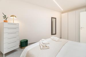 米兰Urban Garden by Blue Velvet Livings的一间白色卧室,配有一张床和一个梳妆台