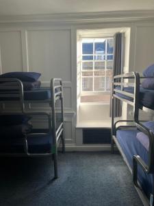 巴斯Bath Backpackers的客房设有两张双层床和一扇窗户。