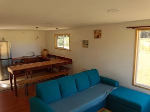 弗鲁蒂亚尔Cabaña familiar的客厅配有蓝色的沙发和桌子