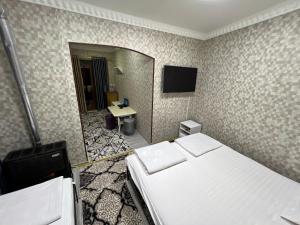 布哈拉Hotel Uncle Kolya Boutique的酒店客房,设有两张床和镜子